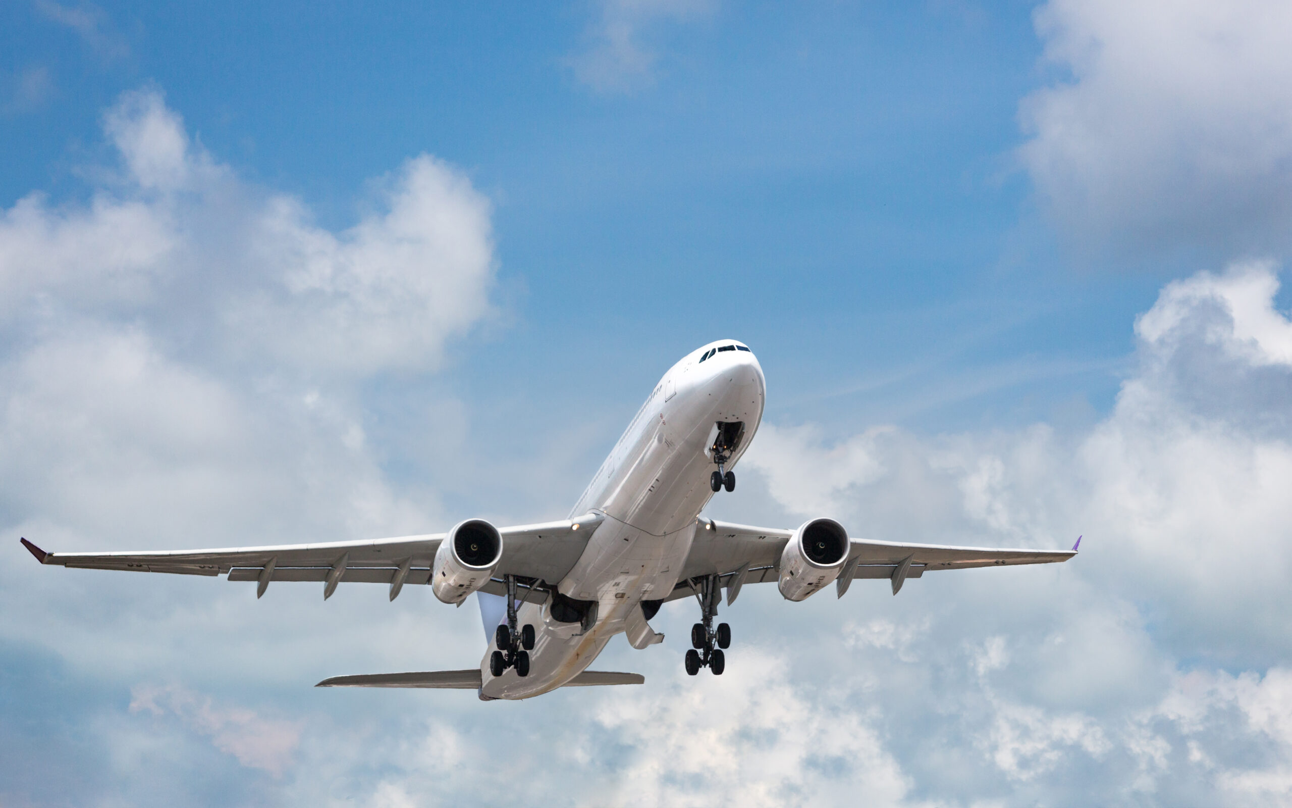 Passenger airplane taking off in bright cloudy sky. Wide-body co
