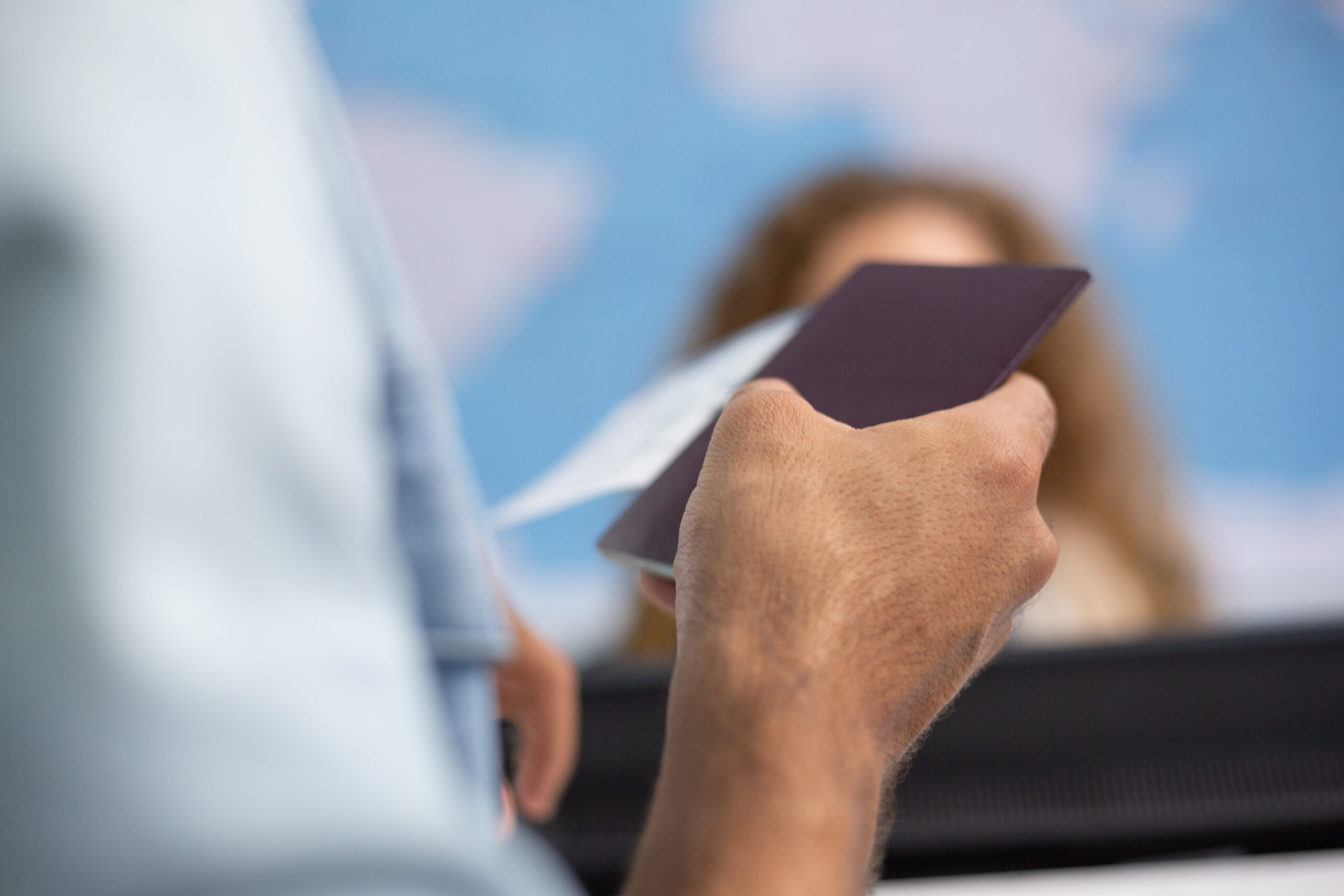 Hand of tourist passenger holding passport at the check in count