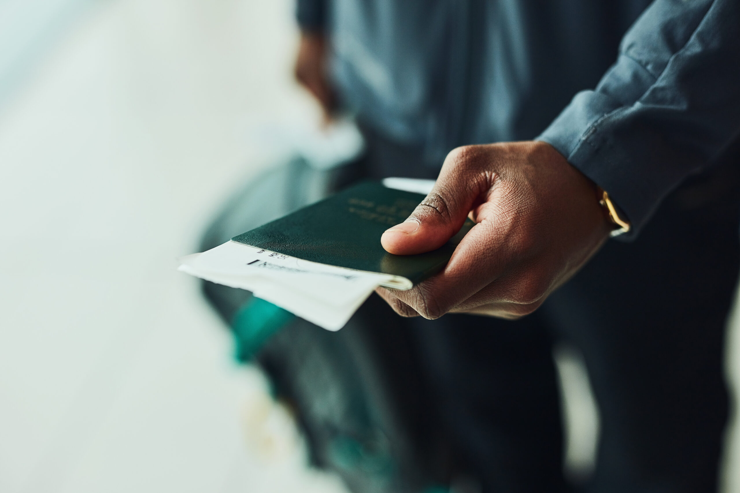 Shot of an unrecognizable person holding his passport indoors.
